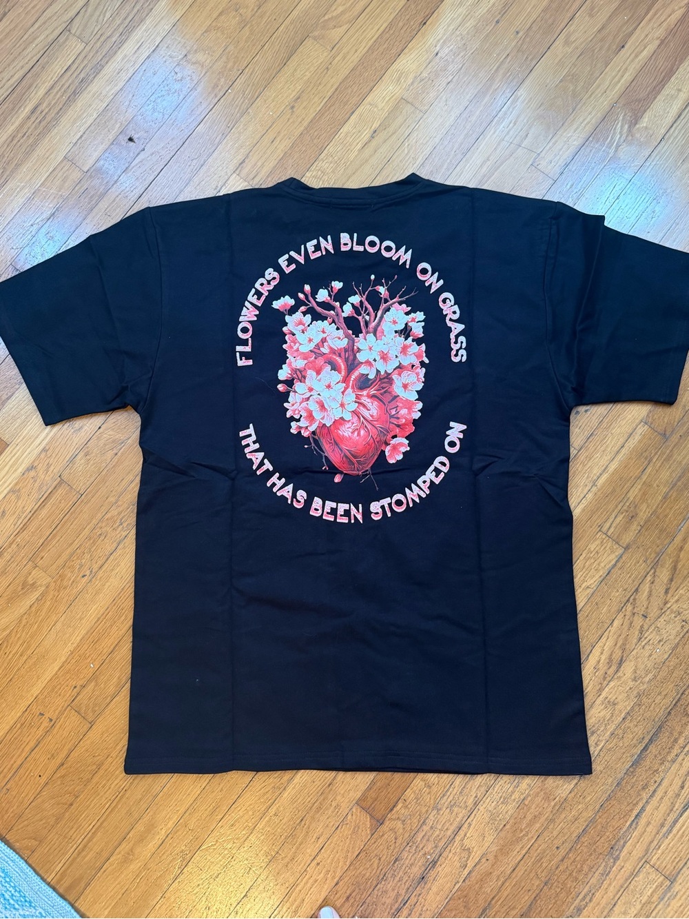 “Even Flowers Bloom on Grass That Has Been Stomped On” T-Shirt